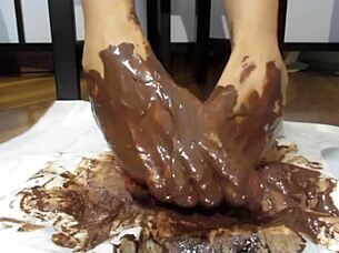Feet with varnished nails covered in chocolate cream.