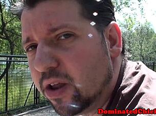 busty submissive tied up in bdsm, subtly dominating by deepthroating master's hard cock in a fetish scene.