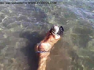 Look at that milf playing with her big tits and ass on the public beach!