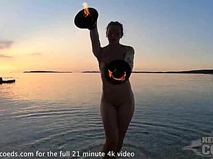 Nude fire dancing on the beach at sunset