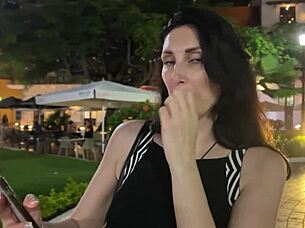 In a bustling restaurant, a girl performs a blowjob on her partner discreetly.