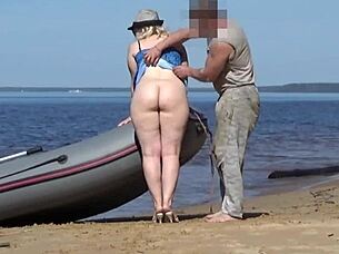 lady tourist interacts with boatman on beach