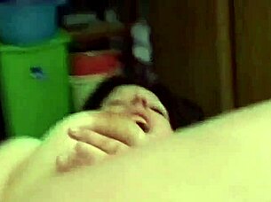 Titty slut fingers her pussy with a dildo while watching porn