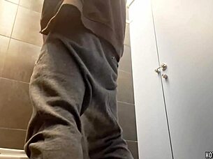 A sexy bodybuilder takes a risky chance masturbating in a public bathroom.