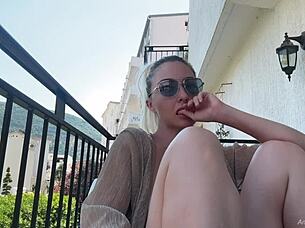 Blonde exhibitionist flashes natural tits on balcony in public nudity