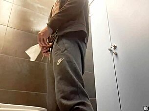 A sexy bodybuilder takes a risky chance masturbating in a public bathroom.