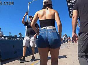In a public outdoor setting, a voyeur captures a candid shot of a big ass in tight shorts and jeans.