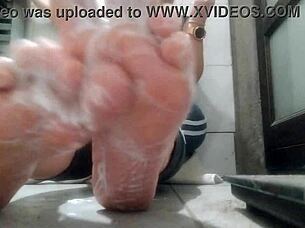 woman shows her feet and applies lubricant in close up view