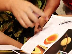 The hot teacher explains astronomy to her students in the classroom.