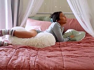 the cute asian girl starts humping her pillow in a solo masturbation session