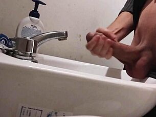 Resting balls on the sink while preparing cock for a huge cumshot.