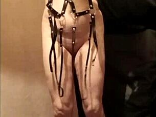 Female slave self-session in leather harness outdoors