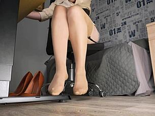 Secretary teases with feet in nude stockings under desk