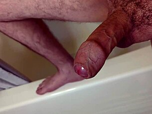 A person masturbates in the bathroom before getting into the shower for bathing.