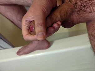 A person masturbates in the bathroom before getting into the shower for bathing.