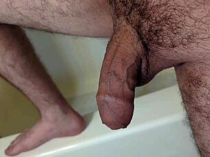 A person masturbates in the bathroom before getting into the shower for bathing.