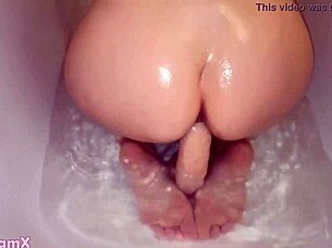 Young amateur girl with a big figure enjoys a relaxing shower using toys for a satisfying moment