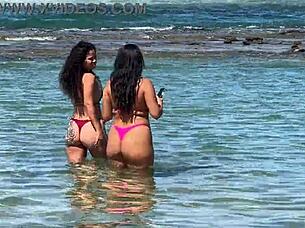 Two beautiful Brazilian women enjoy their first time kissing and exploring on the sunny beach. Their curvy bodies shine under the sun in this outdoor adventure.