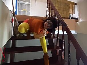 Halloween witch in pantyhose teases with pumpkins and broom in old house stairway performance