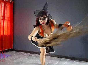 Halloween witch in pantyhose teases with pumpkins and broom in old house stairway performance