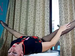 Nice lady in pantyhose and heels starts undressing at round table. She teases with juicy curves in intriguing striptease.