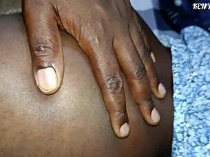 African couple enjoys close up bent over doggystyle sex on bed at night.