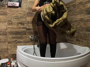 i can't believe this milf is peeing in the bathtub with fur coat and pantyhose on!