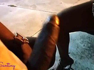 Hey, check out this hot big-ass chick jerking off that massive cock right in the middle of the square!