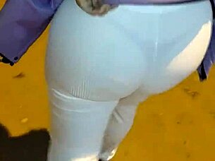 Mature woman with big ass walks down the street in thong under transparent leggings.