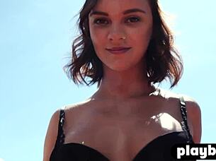 Petite blonde model posed in lingerie for outdoor striptease.