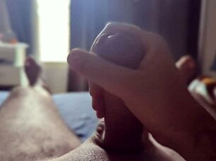 Solo guy masturbates his big cock with sun rays streaming through the bedroom window