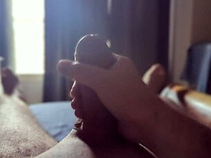 Solo guy masturbates his big cock with sun rays streaming through the bedroom window