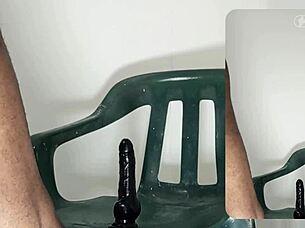Johnazino starts riding black dildo on green plastic chair