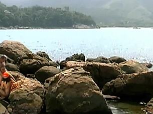 A horny mature guy pounds exotic babe in cap and shades on seaside rocks 💦👓