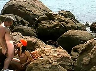 A horny mature guy pounds exotic babe in cap and shades on seaside rocks 💦👓