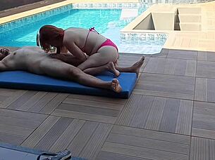 Redhead babe rides cock hard by the pool