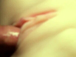 Flushing lube deep into shaved pussy close-up