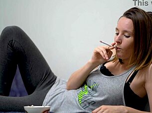 Beautiful petite brunette babe with blue eyes smokes teasingly in voyeur view