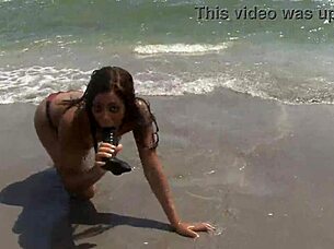 Ebony babe fucks dildo on public beach