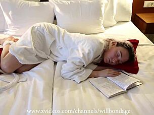 sofi lounges in tied dressing gown flipping book pages casually