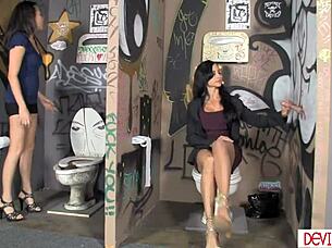 Stepmom and young woman slurp huge cock in public toilet