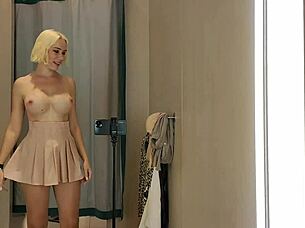 Blonde flashes big tits through see-through clothes in public mall changing room spy thrill