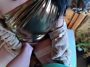 A mature woman in golden dress bends over freezer for intense action