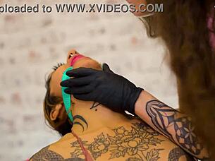 latex duo's spit-lubed double dildo tempts submission