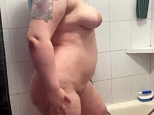 Chubby tattooed babe teases dripping shower curves
