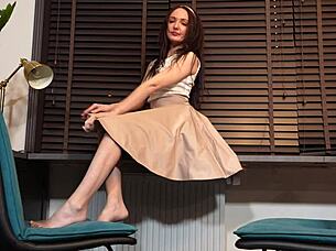 Emily in skirt and pantyhose rubs legs teasingly