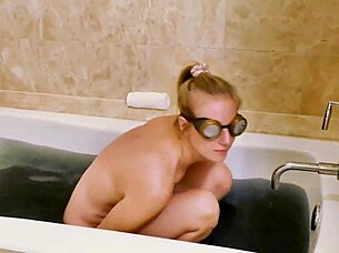 Watch this blonde milf play nude in the bathtub, showing her pussy and ass.