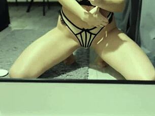 A beautiful girl masturbates while watching herself in the mirror