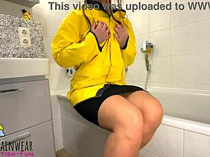 girl in yellow rubber raincoat playing with a rubber duck teaser