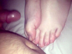 Amateur performs footjob on cock in 69 position, stroking with feet
